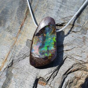 Pendentif Opale Boulder : Une Forme Concave aux Reflets Verts et Rouge