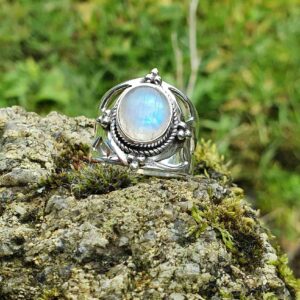 Bague en pierre de lune aux reflets bleus, sertie sur un modèle de bague de la collection Triskell