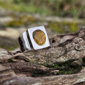 Bague chevalière œil de tigre et argent massif 925. Taille 60. La pierre taillée finement diffuse ses reflets. Un bijou unique pour allier élégance et protection.